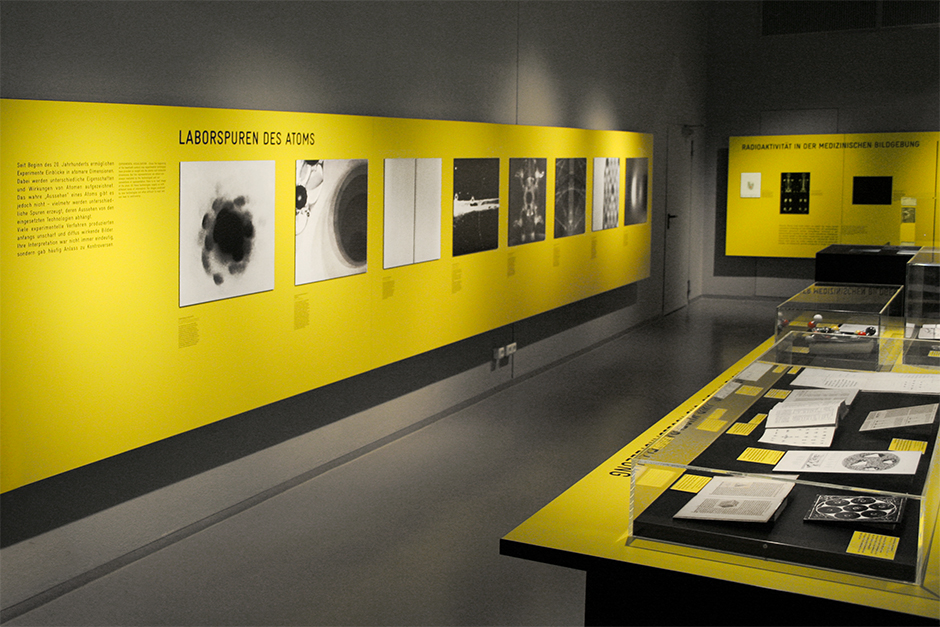 Ausstellungsarchitektur. Gelbe Grafiken-Wand.