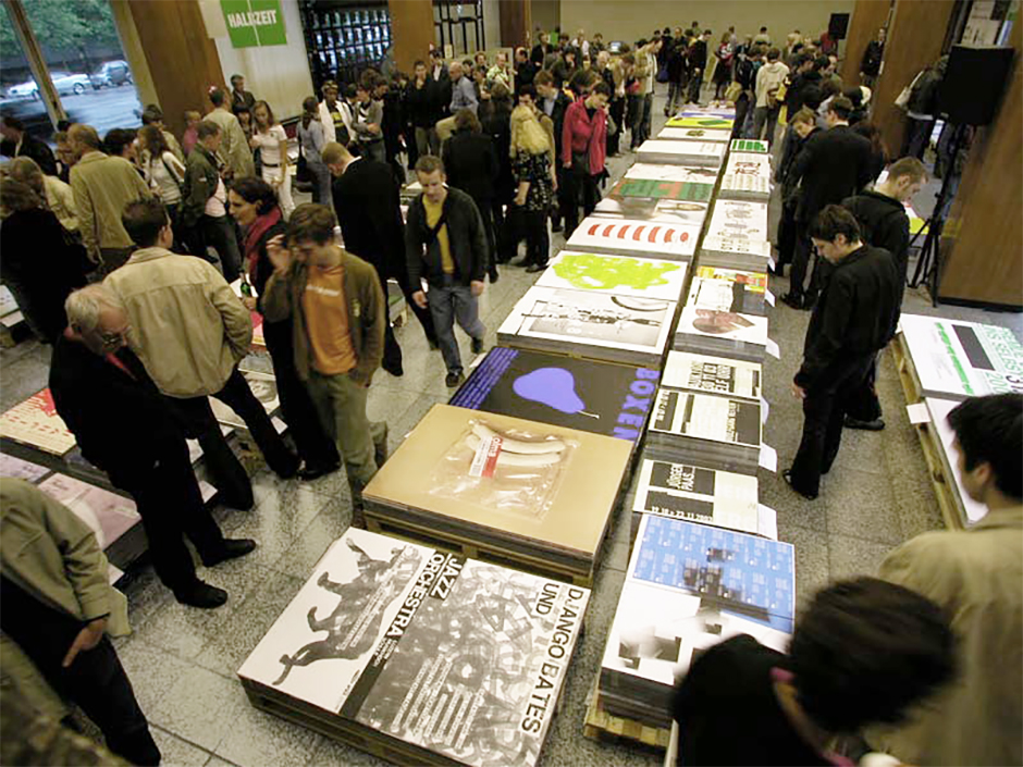 Ausstellungsdesign. Plakate auf Paletten, umgeben von Besuchern.