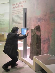 Museumsgestaltung. Besucher vor interaktivem Teil der Ausstellung.